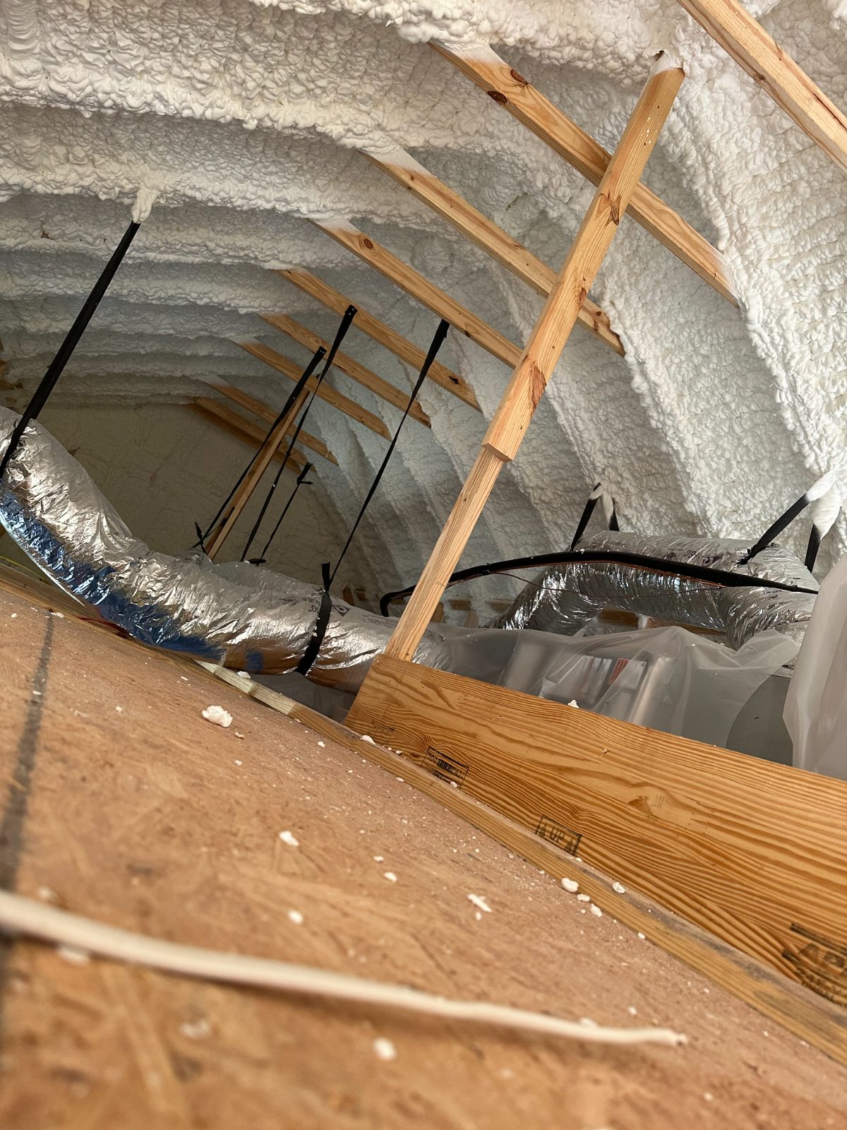 Open-cell spray foam ceiling framing with electrical runs exposed